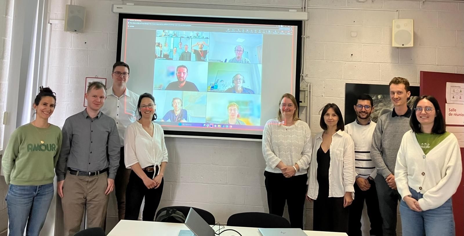 STITCHING partners at the kick-off meeting in Louvain-la-Neuve, in front of a screen showing the partners joining online